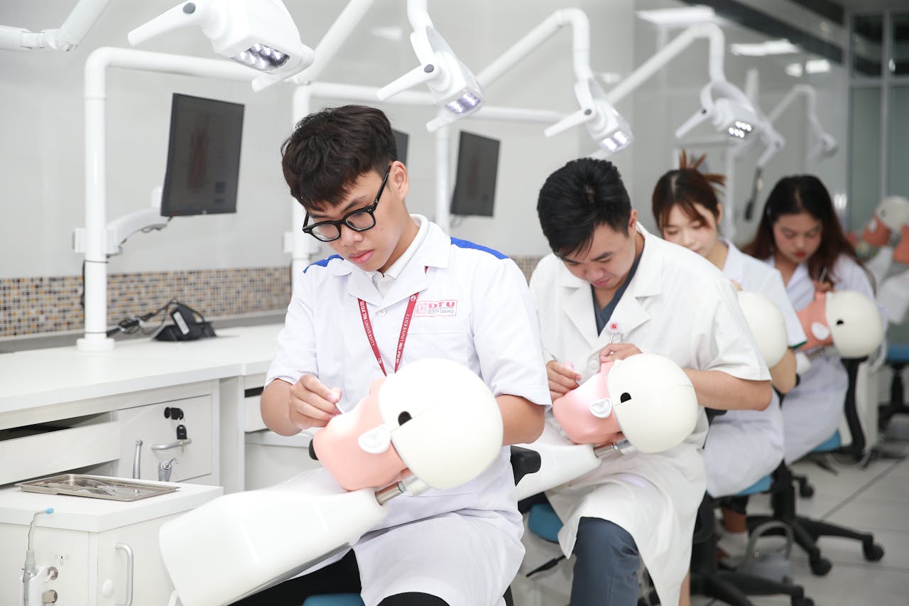 Dental students in a training lab practicing on mannequin heads for skill development.
